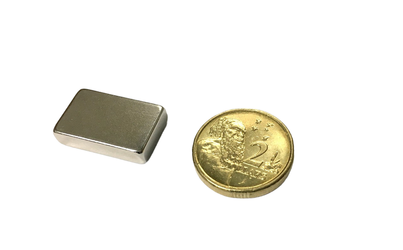 a gold coin next to a silver square magnet