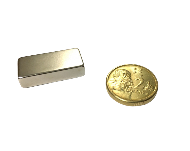 a gold coin next to a metal money clip