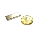 a gold coin sitting next to a metal money clip