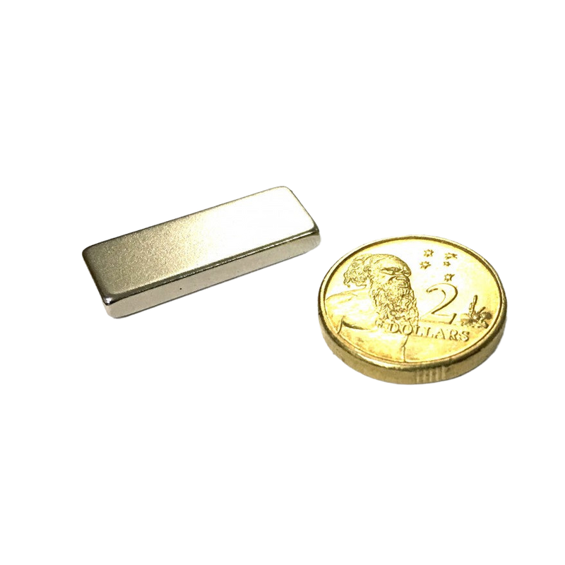 a gold coin sitting next to a metal money clip