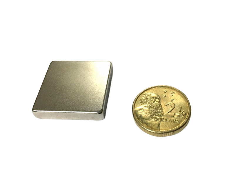 a gold coin sitting next to a metal box