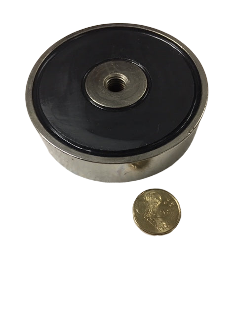 a coin sitting next to a black and silver object