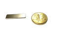 a small metal bar next to a gold coin