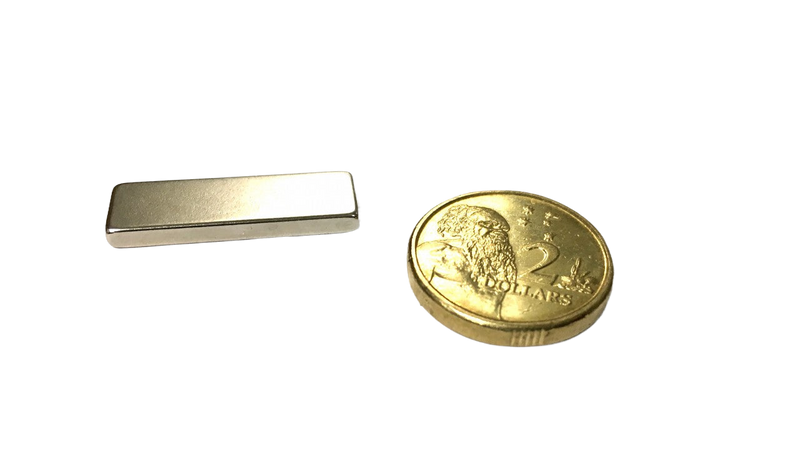 a gold coin and a silver bar on a black background