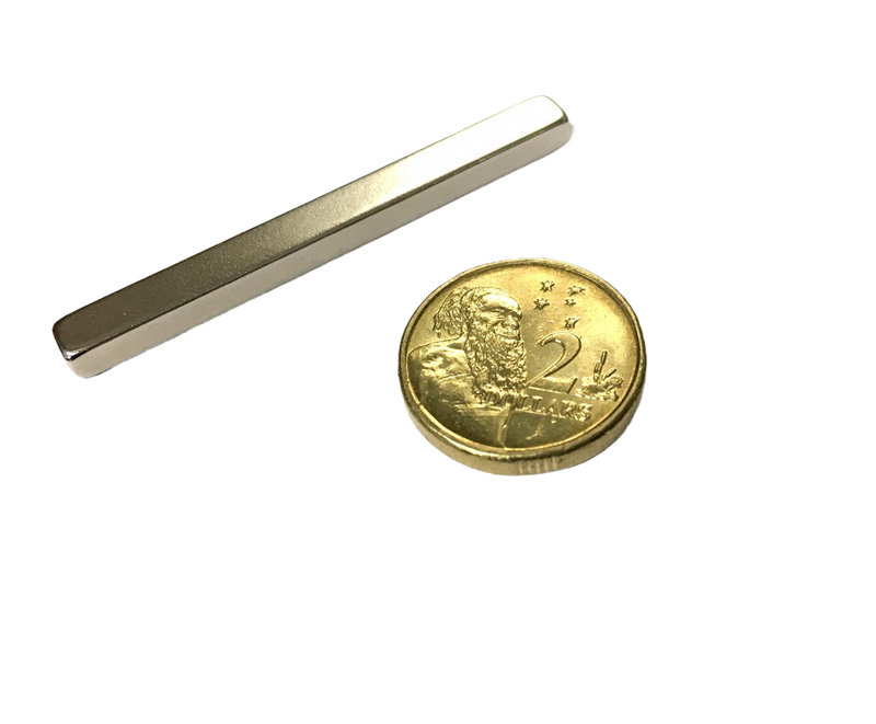 a metal bar and a gold coin on a black background