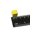 Yellow 13mm plastic coated neodymium block magnet shown against a measuring scale