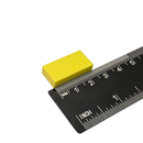 25.4mm x 12.7mm x 6.3mm yellow plastic coated neodymium block magnet shown beside a ruler for scale
