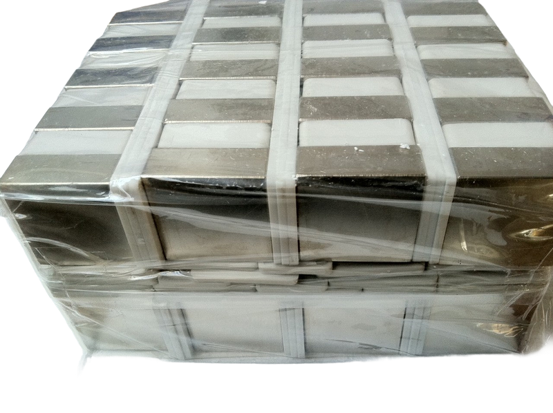 a stack of white and grey tiles wrapped in plastic