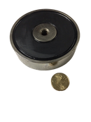 a coin sitting next to a black and silver object