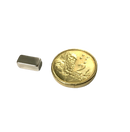 a small metal object next to a gold coin