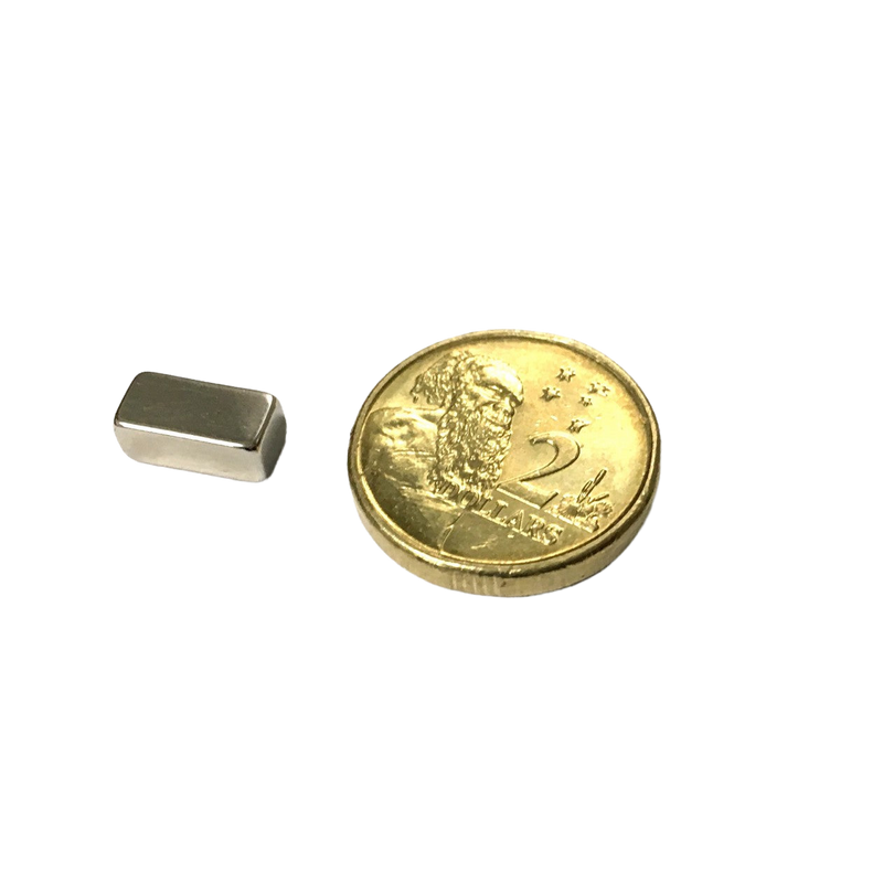 a small metal object next to a gold coin