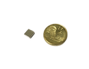 a gold coin and a small metal object on a black background