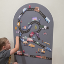 Child building a road layout with magnetic roads and vehicles on a magnetic arch wall decal